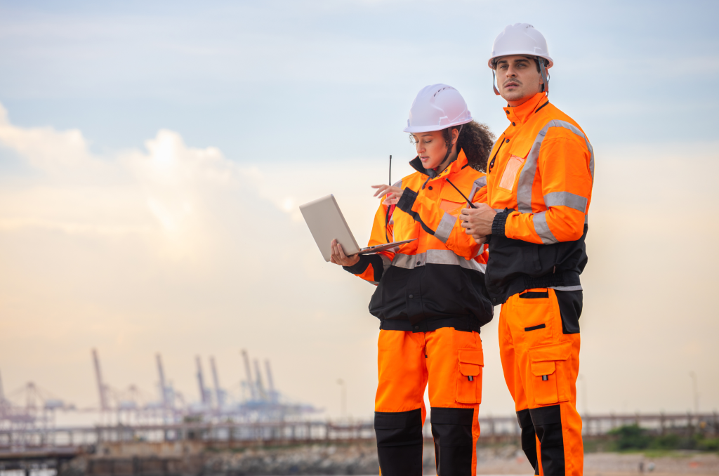 Engenheiros com laptop em área industrial realizando monitoramento técnico voltado ao aumento do MTBF e à confiabilidade de selos mecânicos.